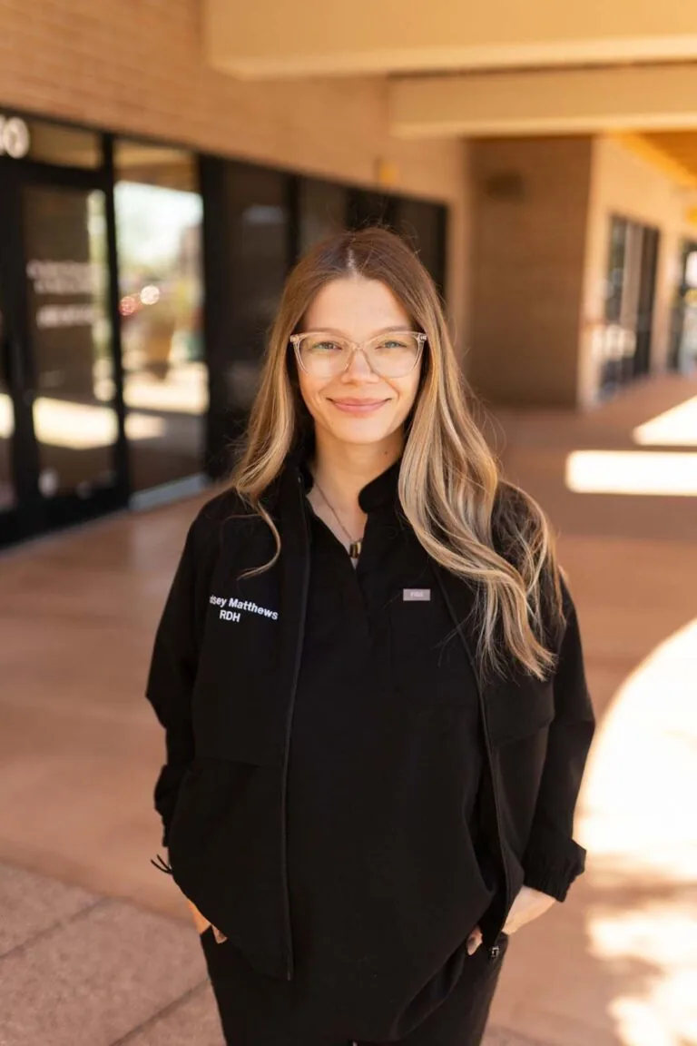 A woman standing in hallway with her both of her hands in the pockets.