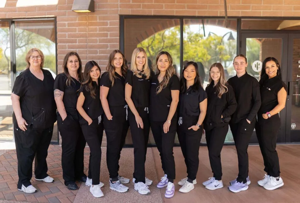 Group photo of Bria Dental, wearing black scrubs and sneakers.